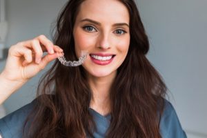 woman holding clear aligners