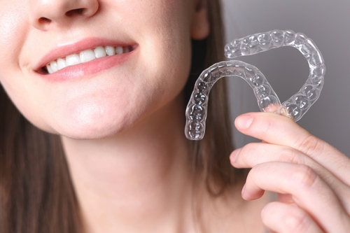 woman holding clear aligners