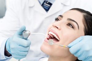 woman getting a dental exam and cleaning 
