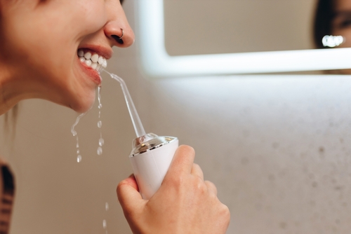 woman using a water flosser