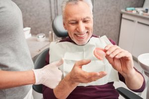 man holding dentures