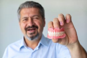 man holding a set of dentures